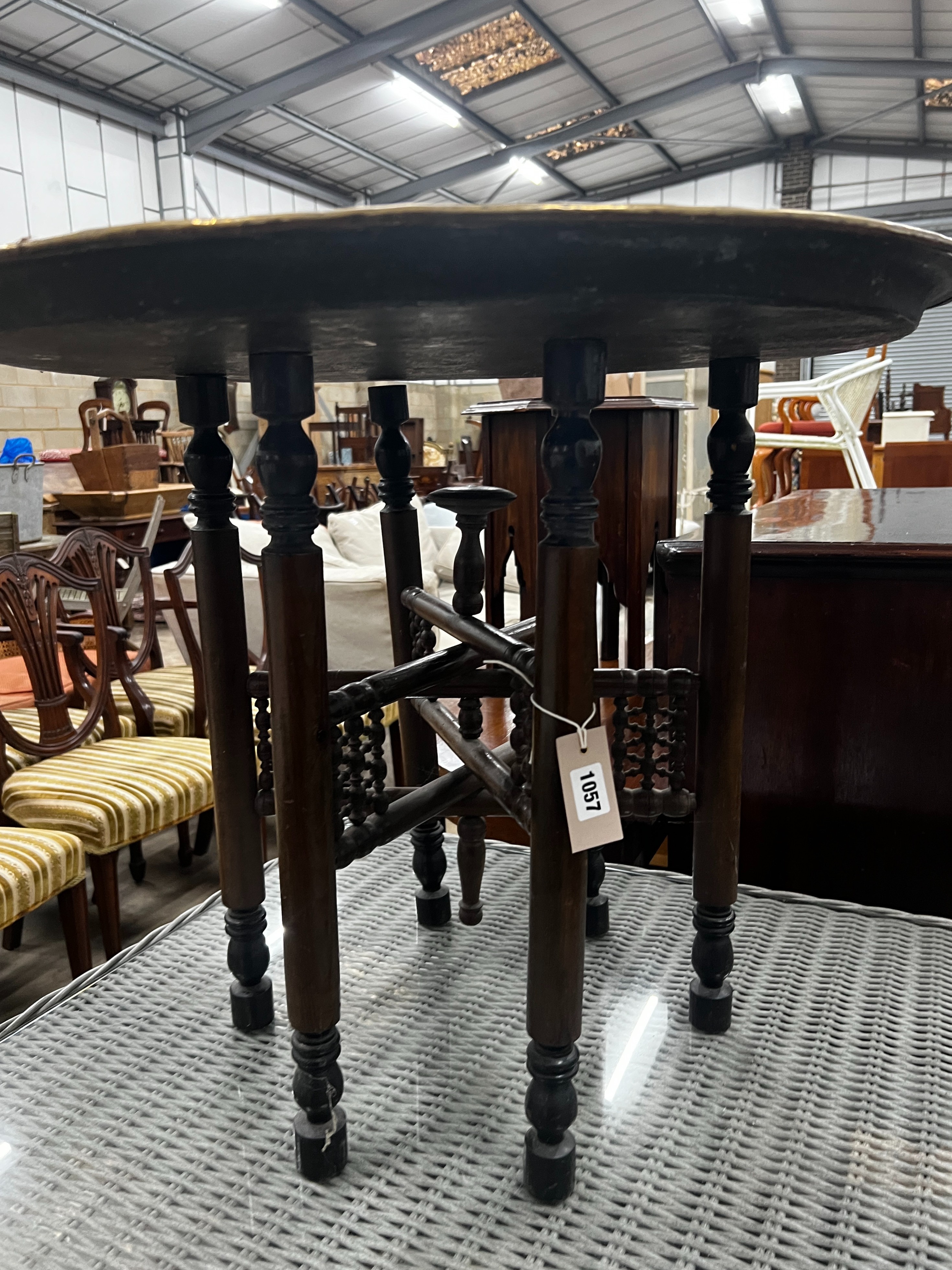 A Benares engraved brass circular tray top table on folding stand, diameter 67cm, height 59cm